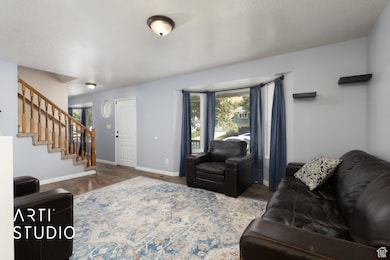 Living area with stairway, wood finished floors, and a textured ceiling