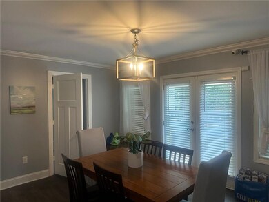 Dining space featuring crown molding, baseboards, and dark wood-style floors