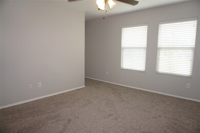 Carpeted empty room with baseboards and ceiling fan