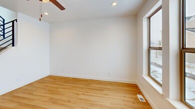 Empty room featuring light wood finished floors, recessed lighting, a ceiling fan, and stairs