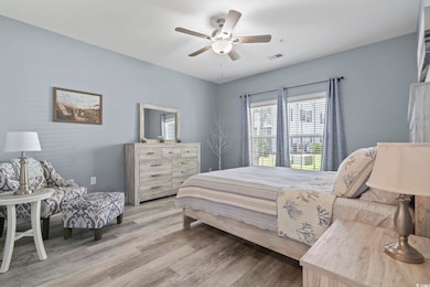 Bedroom with light wood finished floors and a ceiling fan