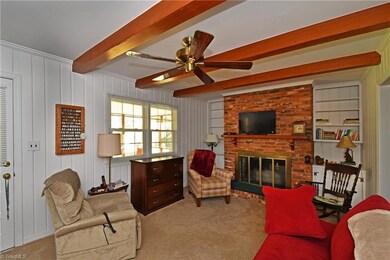 Den with fireplace has access to screened porch