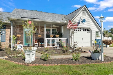 View of front of property with brick siding, roof with shingles, covered porch, driveway, and a garage