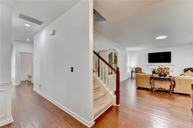 Hallway featuring recessed lighting, light wood-style flooring, stairs, and ornamental molding