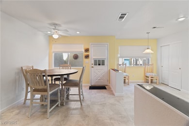 Dining area featuring light tile patterned floors, ceiling fan, and recessed lighting