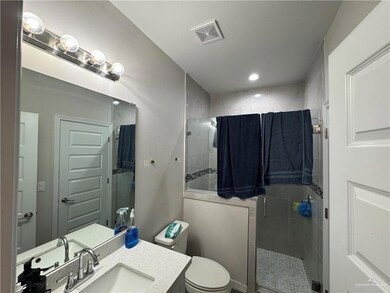 Bathroom featuring a shower stall, vanity, toilet, and recessed lighting