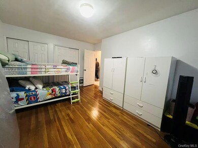 Bedroom with dark wood-type flooring and multiple closets