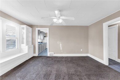 Carpeted spare room featuring ceiling fan
