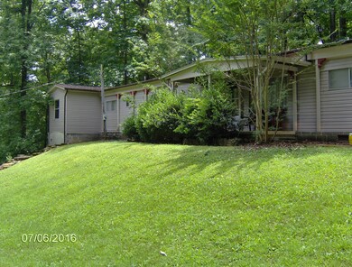 manufactured unit with the end having a large built on den, has storage garage underneath.