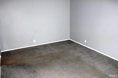Spare room featuring dark carpet