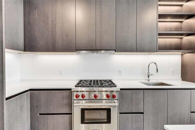 Kitchen featuring open shelves, premium stove, modern cabinets, and light stone countertops