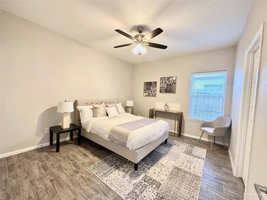 Bedroom with ceiling fan and dark wood-type flooring