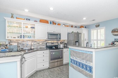 Kitchen with white cabinetry, decorative backsplas