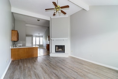 Unfurnished living room with a fireplace, light wood-type flooring, and ceiling fan