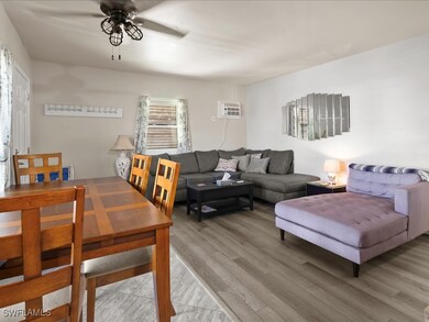 Living room with ceiling fan, light wood-style flo