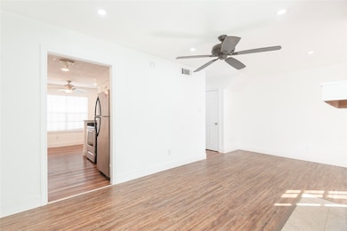 Unfurnished room with light wood finished floors, a ceiling fan, and recessed lighting