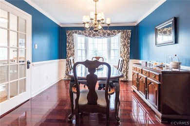 Gorgeous floors and bay window with chair rail make for an elegant dining room