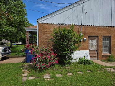 View of side of property featuring a lawn, brick s