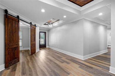 Foyer with custom barn doors leading into office/