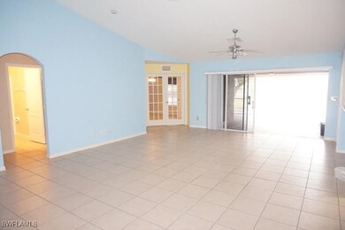 Unfurnished room featuring vaulted ceiling, french