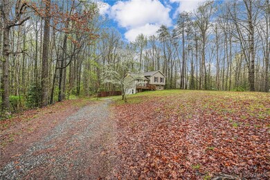 View of front of home with a forest view, a wooden