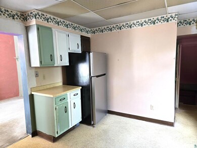 Kitchen with a paneled ceiling, light carpet, and 