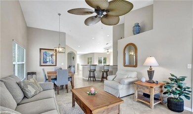 Tiled living room featuring high vaulted ceiling a