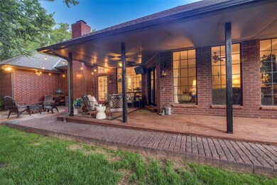 Rear view of house with a chimney, a fire pit, brick siding, a patio, and a wooden deck