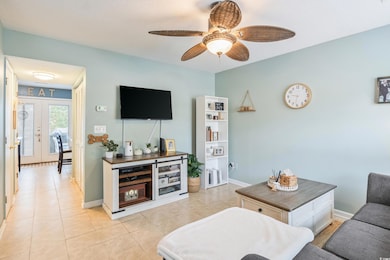 Living room featuring ceiling fan, light tile patt