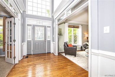 Foyer view into the office, the front entrance to the home and into the living room. 2-story foyer includes Palladian window, transom window entrances into the office and the living room, crown/chair/picture mouldings, stairway to the 2nd level, a 4X3 closet and the 8X5 half bathroom with hardwood floor.