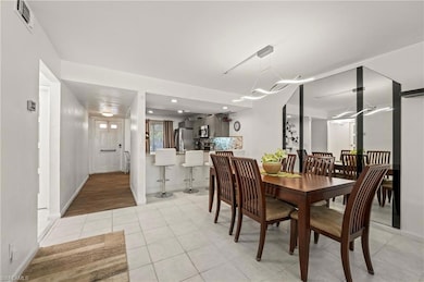 Dining space featuring light tile patterned floors, baseboards, and visible vents