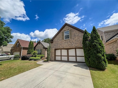 Tudor home with brick siding, driveway, an attache