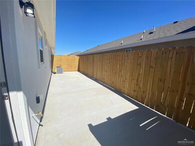 Fenced backyard with a patio and cooling unit