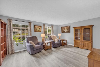 Sitting room featuring wood finished floors, a textured ceiling, and baseboards