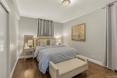 Bedroom with baseboards and dark wood-style floors