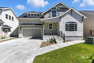 View of front of property featuring an attached garage, driveway, and stone siding