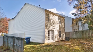 Rear view of house with a fenced backyard and a patio