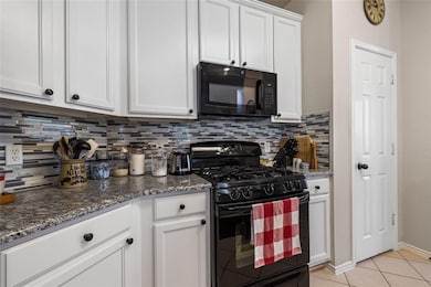Kitchen with black appliances, decorative backspl