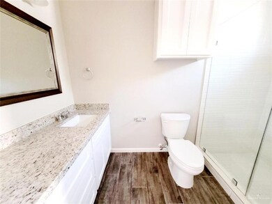 Full bath with baseboards, toilet, tiled shower, wood finished floors, and vanity