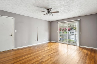 Spare room with a ceiling fan, hardwood / wood-style flooring, and a textured ceiling