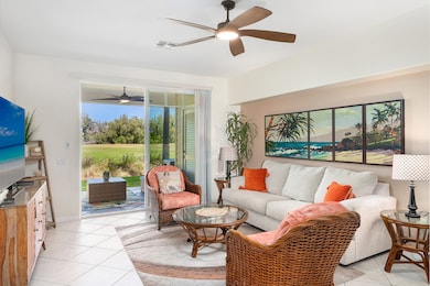 Fairway Villas Waikoloa Beach Resort condo E2—spacious living room with sofa, chairs, stylish furnishings, and seamless access to the private lanai with golf course views.