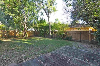The large backyard is surrounded by a wood privacy