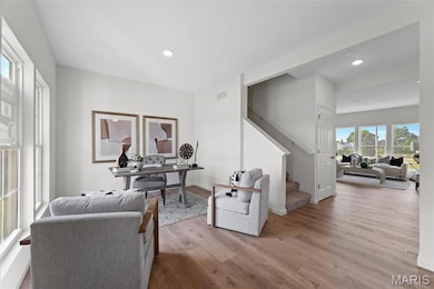 Home office featuring healthy amount of natural light, wood finished floors, and recessed lighting