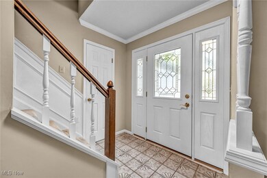Tiled entrance foyer featuring crown molding