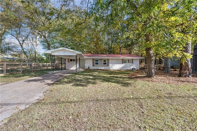 View of front of home featuring concrete driveway, an attached carport, and brick siding