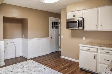 Kitchen has white painted cabinets.