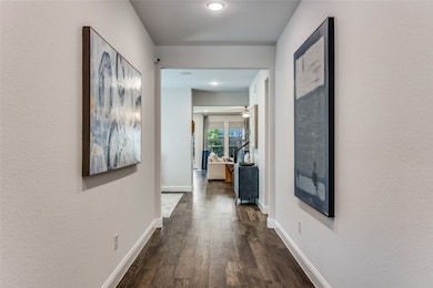 Hall with dark wood-style floors and a textured wall