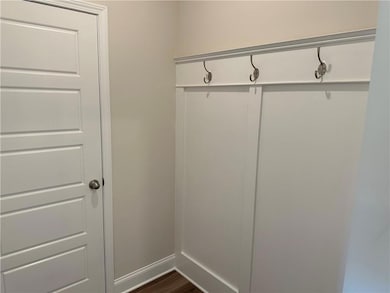 Mudroom featuring dark wood-style floors and baseb
