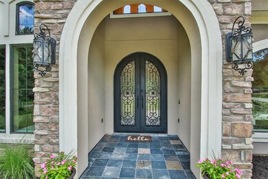 An incredible warm and inviting front porch elevation is accented with slate floors and ornamental steel iron doors. The stone and stucco finishes are picture perfect.
