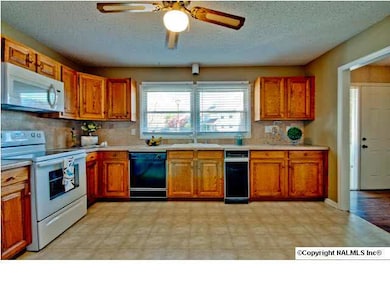 Another view of kitchen with eating area an view of closet with washer & dryer
